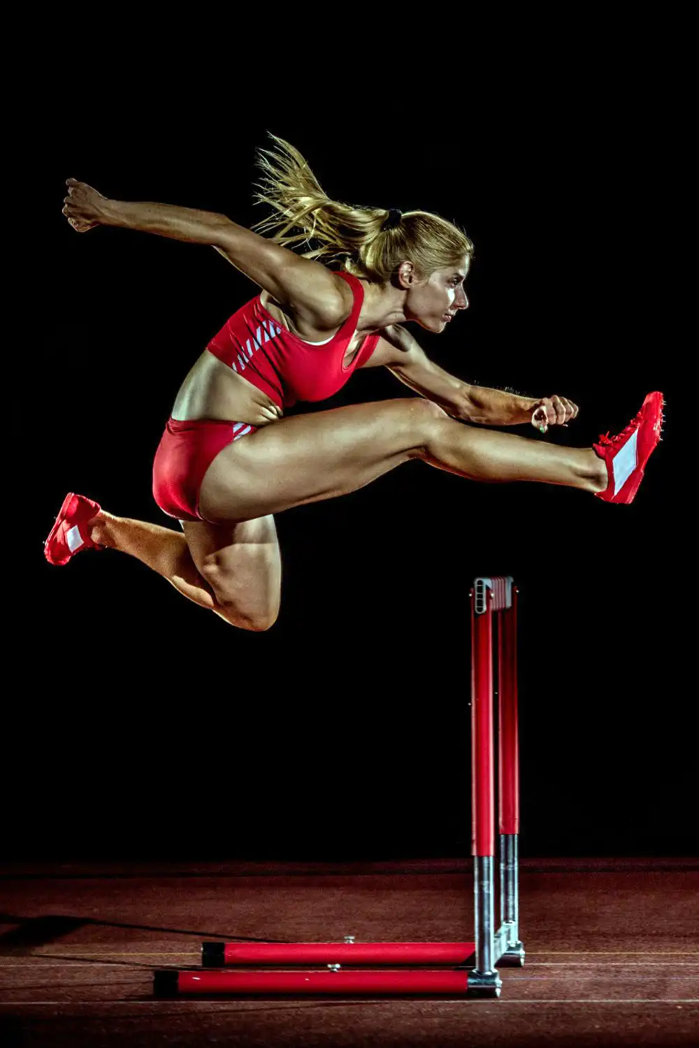 Female athlete jump on the hurdle