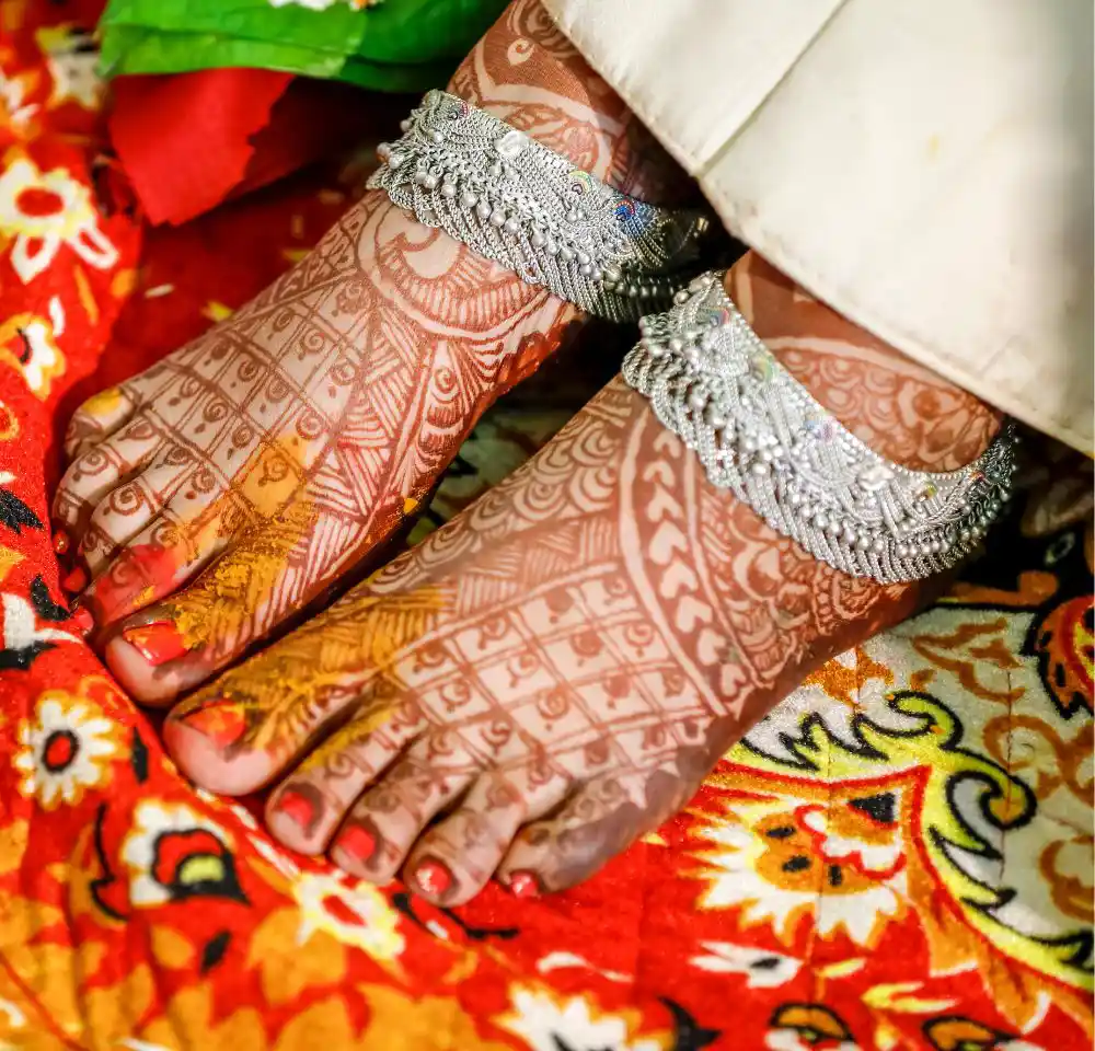 Indian bridal putting anklets in leg