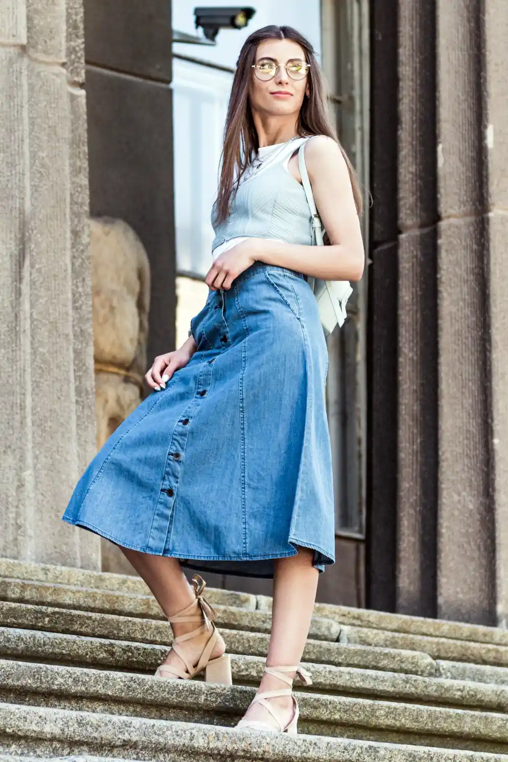 Woman in long denim skirt standing on steps