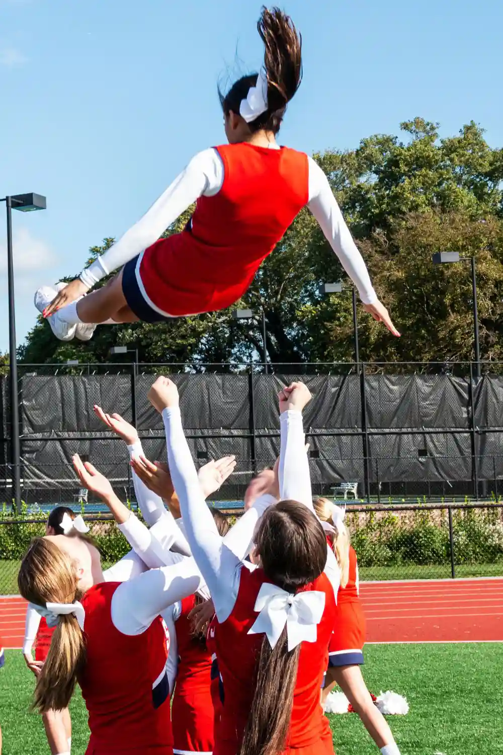Cheerleading squad catching their teammate during practice