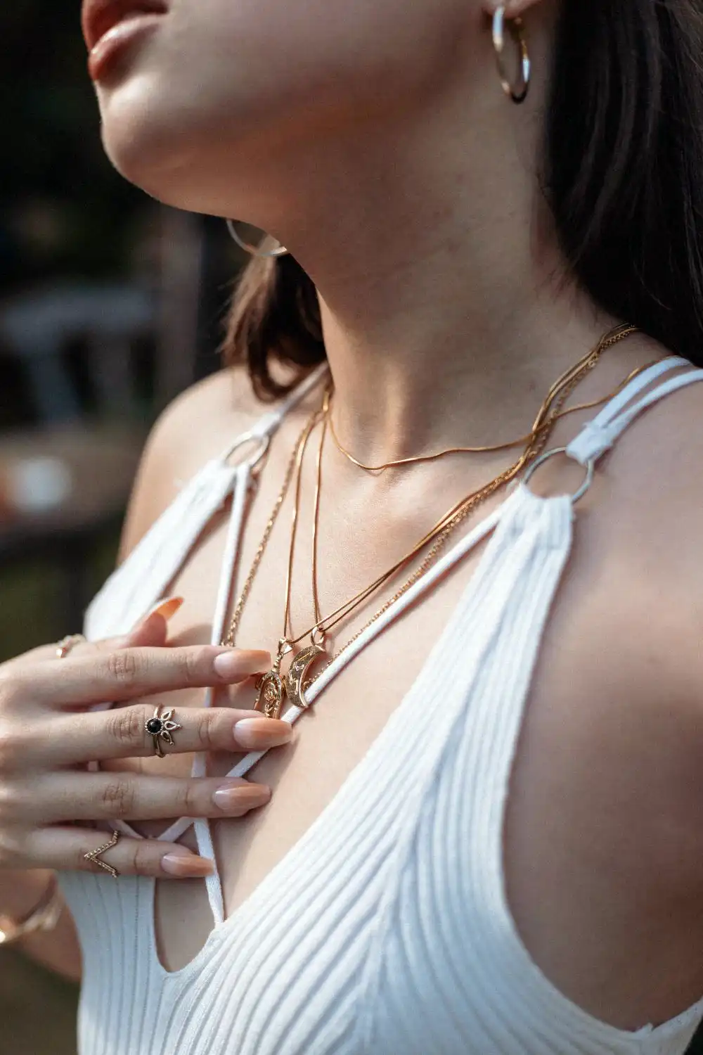 Woman Wearing Gold Necklaces, Rings, and Earrings