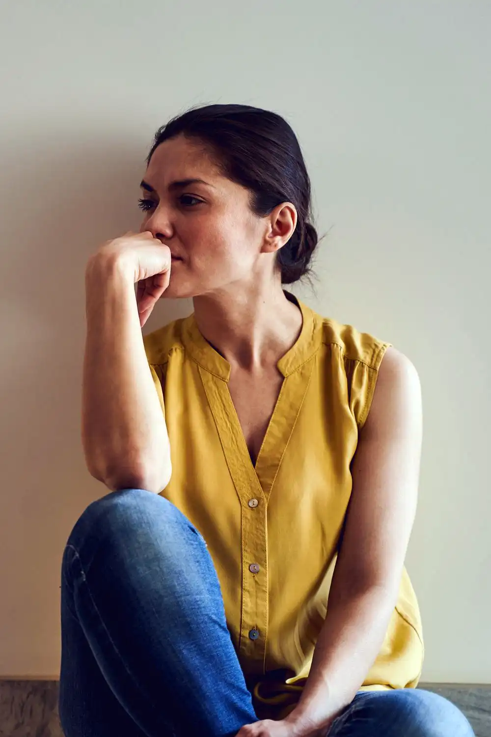Woman in a sleeveless blouse staring away